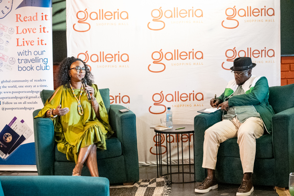 Two speakers sit in armchairs during a talk with microphones and a branded Galleria backdrop behind them.
