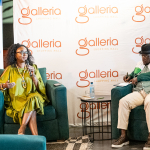 DZ6 2131 Two speakers sit in armchairs during a talk with microphones and a branded Galleria backdrop behind them.