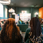 DZ6 2188 Wide view of attendees seated in a lounge venue facing the discussion area.