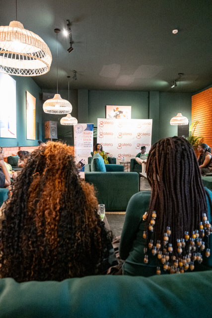 Wide view of attendees seated in a lounge venue facing the discussion area.