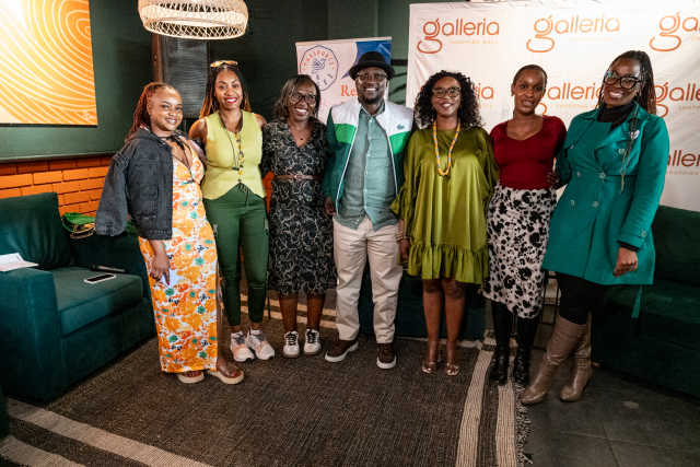 Seven guests pose together in front of a Galleria-branded backdrop