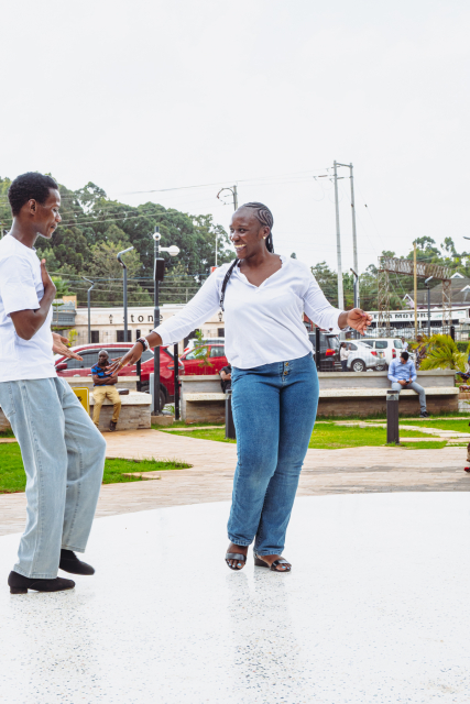 A smiling woman dances with a man on the mall's outdoor plaza