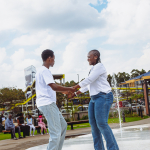 Dancers Performing Beside the Fountain Two dancers hold hands while performing on the wet courtyard surface beside the mall fountain.