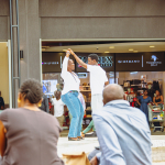 Dance Performance Viewed from the Audience Two dancers perform together in the mall courtyard while spectators watch from the foreground.