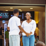 Smiling Dancer Outside the Mall A smiling woman holds hands with a man outside a mall storefront