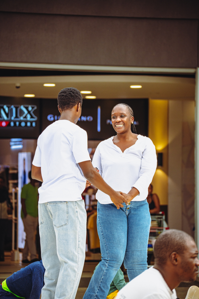 Smiling Dancer Outside the Mall A smiling woman holds hands with a man outside a mall storefront