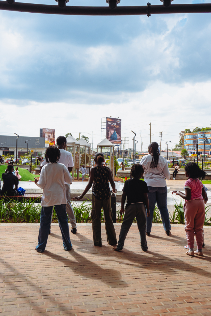Five visitors stand on a brick terrace looking across the outdoor mall area.